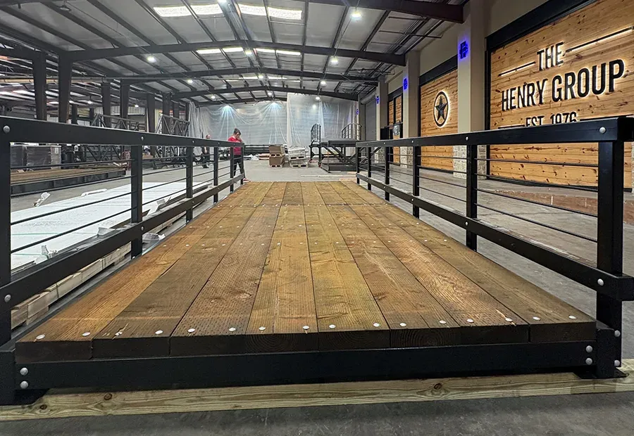 Modular pedestrian bridge with steel rails and wood deck, preassembled in factory.